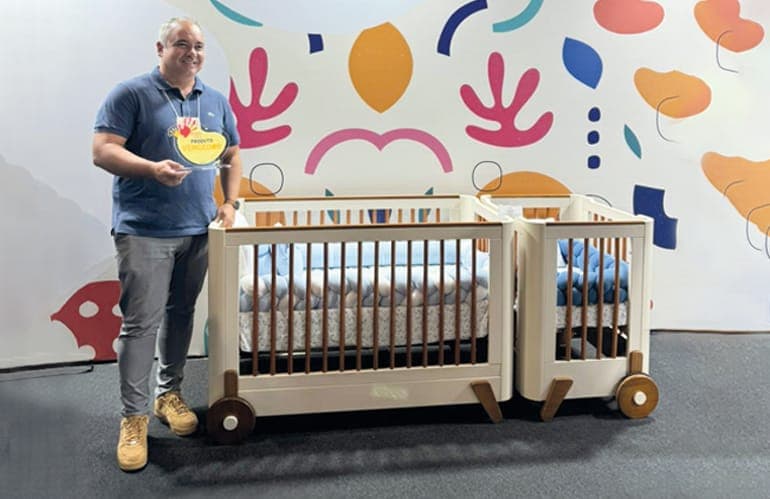 Maic Caneira, diretor da Matic Móveis, recebe o prêmio ao lado do berço Fun