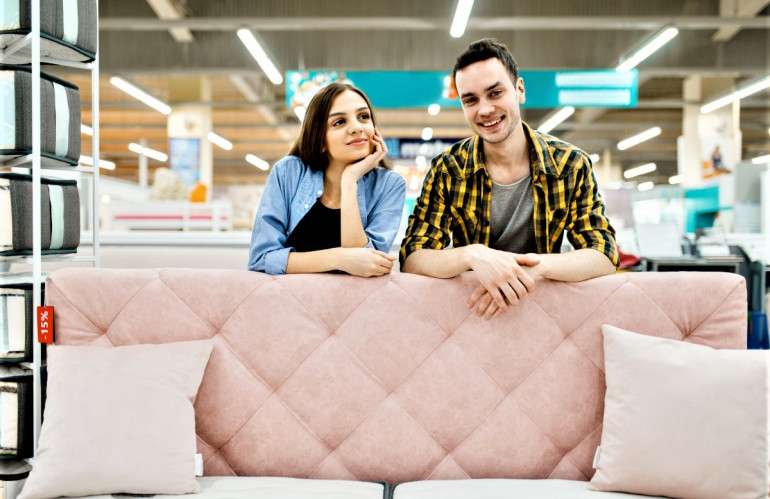 young-love-couple-poses-at-the-pink-couch-in-furniture-store.jpg