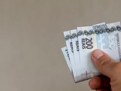 hand-holding-brazilian-money-bills.jpg