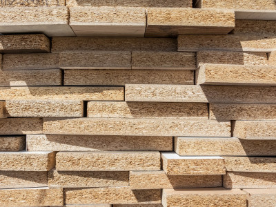 a-stack-of-particle-boards-is-located-outdoors-in-a-lumber-yard.jpg