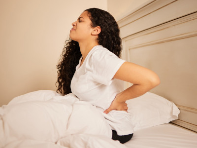 i-woke-up-with-bad-backache-shot-of-a-young-woman-holding-her-stomach-in-pain-in-bed-at-home.jpg