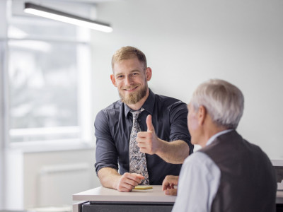 portrait-of-smiling-businessman-showing-thumb-up-sign-in-the-office.jpg