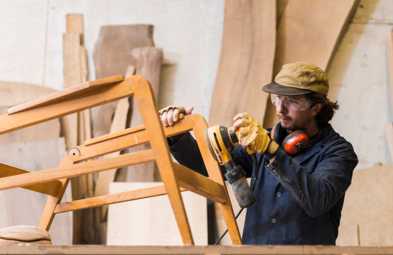 carpinteiro-masculino-lixar-uma-madeira-com-lixadeira-orbital-em-uma-oficina.jpg